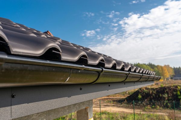 a-metal-black-gutter-on-a-roof-covered-with-ceram-2025-03-12-21-49-17-utc